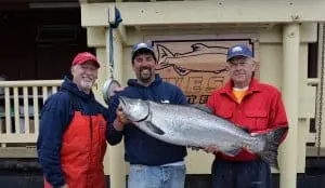 fish-16 Three men pose in front of King Pacific Lodge with their King salmon catch