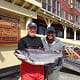 Two men holding Chinook salmon in front of King Pacific Lodge