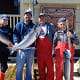 Three men and a woman pose in front of King Pacific Lodge with their King salmon catch