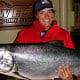 A woman holding a big Chinook salmon catch in King Pacific Lodge